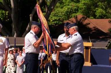 GEN John Lorber relinquishes command of PACAF by passing the command flag with battle streamers to GEN Ronald Fogelman, Air Force CHIEF of STAFF