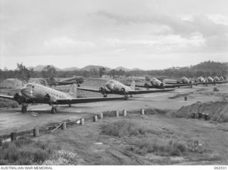 WARD'S DROME, PORT MORESBY AREA, PAPUA, NEW GUINEA. 1944-01-06. DOUGLAS C47 DAKOTA TRANSPORT AIRCRAFT LINED UP ON WARD'S DROME, LOADED WITH PERSONNEL OF 57/60TH AUSTRALIAN INFANTRY BATTALION, ..