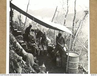 SHAGGY RIDGE, NEW GUINEA. 1944-01-20. PERSONNEL WORKING IN THE COOKHOUSE OF A COMPANY 2/9TH INFANTRY BATTALION ON A HILLSIDE SOME 200 YARDS FROM THE JAPANESE FORWARD POSITIONS. SHOWN ARE: QX30805 ..