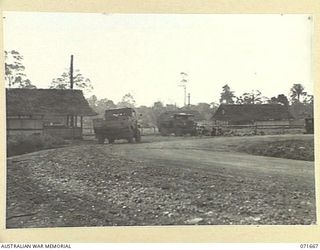 LAE, NEW GUINEA. 1944-03-24. THE VEHICLE ENTRANCE TO HEADQUARTERS LAE BASE SUB-AREA SHOWING THE TRANSPORT OFFICE, CAR PARK, AND THE REGIMENTAL AID POST. (JOINS WITH PHOTOGRAPHS NUMBERED 71668 TO ..