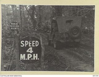 BOUGAINVILLE. 1945-04-30. ROAD SIGNS ERECTED ALONG THE CORDUROY SOUTH OF SLATER'S KNOLL TO ANDERSON'S JUNCTION. THIS SECONDARY TRACK ALLOWS SUPPLIES THROUGH TO 9 INFANTRY BATTALION TROOPS ADVANCING ..