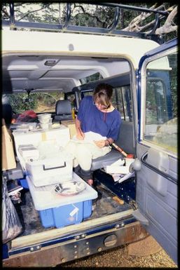 Viv Whitaker writing in back of Landrover