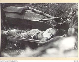 BOUGAINVILLE. 1945-04-05. A 25 INFANTRY BATTALION CASUALTY BEING CARRIED PAST A B SQUADRON, 2/4 ARMOURED REGIMENT MATILDA TANK TO THE REGIMENTAL AID POST FOLLOWING AN ATTACK AGAINST JAPANESE FORCES ..