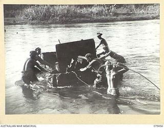 BOUGAINVILLE ISLAND. 1945-03-08. TROOPS OF THE 25TH INFANTRY BATTALION PUSHING AN IMPROVISED RAFT (WIRE MESH AND A TENT FLY) ACROSS THE PURIATA RIVER WHILE TRANSPORTING A TANK ATTACK GUN TO A ..