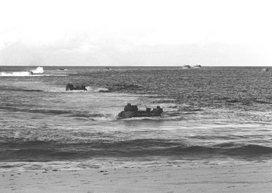 Marines come ashore on Makua Valley Beach in tracked landing vehicles, personnel (LVTP 7s) during Operation KERNEL BLITZ. The LVTP 7s are assigned to the 3rd Amphibious Assault Battalion, 1ST Marine Brigade