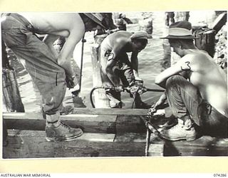 MADANG, NEW GUINEA. 1944-06-26. TROOPS OF THE 2/4TH FIELD SQUADRON WORKING ON THE CONSTRUCTION OF A NEW LIBERTY SHIP WHARF. THEY ARE:- WX20015 LANCE CORPORAL D. CALLAGHAN (1); VX64730 CORPORAL B.W. ..