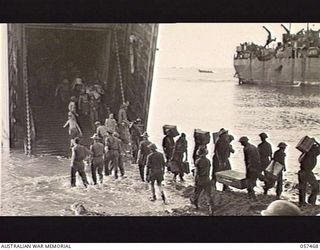 FINSCHHAFEN, NEW GUINEA. 1943-09-22. TROOPS OF THE FINSCHHAFEN FORCE UNLOADING STORES FROM LSTS (LANDING SHIP, TANK) AT THE BEACHHEAD