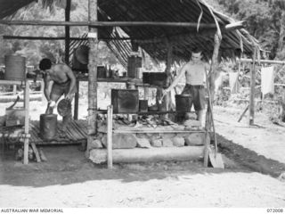 ILOLO - KOKODA, NEW GUINEA. 1944-04-30. NX173474 SIGNALMAN B.G. COMERFORD (1), AND VX125180 SIGNALMAN CREEDON (2), MEMBERS OF THE 18TH LINES OF COMMUNICATION SIGNALS, OCCUPIED IN THE MAKING OF A ..