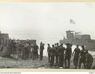 SAMPUN, NEW BRITAIN. 1945-01-13. TROOPS OF THE 6TH FIELD AMBULANCE UNLOADING STORES FROM AN LCM (LANDING CRAFT MECHANISED) DURING A HEAVY RAINSTORM)