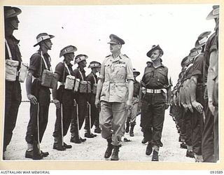 JACQUINOT BAY, NEW BRITAIN. 1945-07-01. HIS ROYAL HIGHNESS, THE DUKE OF GLOUCESTER, GOVERNOR-GENERAL OF AUSTRALIA (1), AND THE GUARD COMMANDER CAPTAIN G. TERRY (2), WALK ALONG THE RANK DURING ..