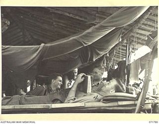 WAREO, PAPUA, NEW GUINEA, 1944-03-29. THE INTERIOR OF A WARD AT B COMPANY, 4TH FIELD AMBULANCE REST CAMP. THE HUTS ARE BUILT FROM LOCAL TIMBER AND COVERED WITH SISALCRAFT. THE MOSQUITO NETTING IS ..