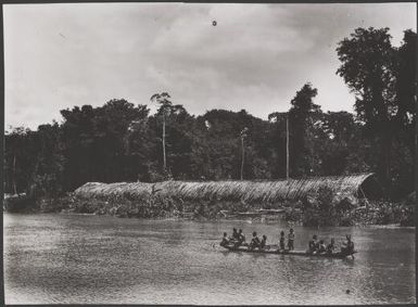 Kiwai men and children in a canoe in front of a communal longhouse on the Bamu River, Papua New Guinea, 1921? Frank Hurley