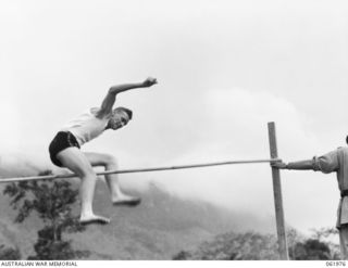 17 MILE, PORT MORESBY AREA, NEW GUINEA. 1943-12-25. PRIVATE MCKENZIE, WINNER OF THE HIGH JUMP, ATTEMPTS 5' 4" AT THE 10TH AUSTRALIAN ADVANCED ORDNANCE DEPOT SPORTS MEETING