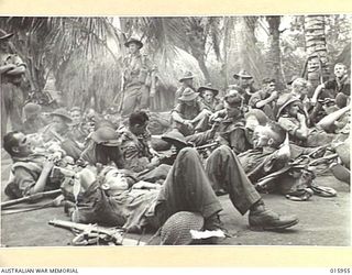1943-10-08. NEW GUINEA. MARKHAM VALLEY ADVANCE. TROOPS REST AFTER A TWENTY MILE MARCH IN THE SWELTERING KUNAI GRASS. (NEGATIVE BY G. SHORT)
