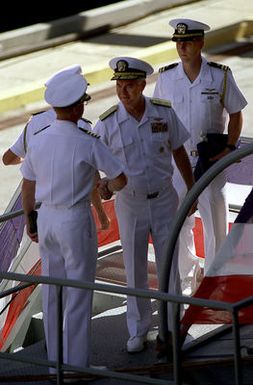 RDML Timothy J. Keating, (center), Commander, Carrier Group Five, is welcomed aboard the aircraft carrier USS KITTY HAWK (CV-63) to raise his pennant as part of the turnover from the USS INDEPENDENCE (CV-62) which is being decommissioned in September 1998. The USS KITTY HAWK will take over as the forward deployed aircraft carrier in Japan