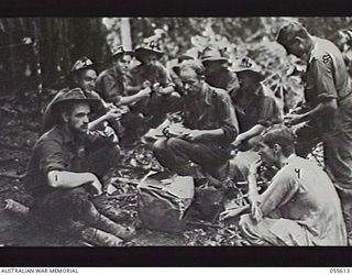 GOODVIEW, NEW GUINEA. 1943-08-11. TROOPS OF THE 2/7TH BATTALION EATING UNDER ADVERSE CONDITIONS. LEFT TO RIGHT: VX11721 PRIVATE (PTE) H. R. HORNE; QX24974 PTE E. R. TOMLINS; VX30564 PTE J. COLLINS; ..