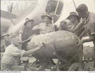 VIVIGANI, GOODENOUGH ISLAND, PAPUA. 1943-11-17. ARMOURERS OF NO. 8 (BEAUFORT) SQUADRON RAAF COMMANDED BY WING COMMANDER G. D. NICOLL CHALK THEIR VISITING CARD ON A 2000LB DAISY-CUTTER BEING LOADED ..