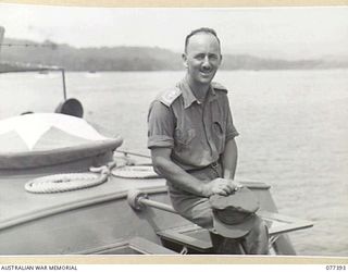 JACQUINOT BAY, NEW BRITAIN. 1944-11-28. VX108122 LIEUTENANT-COLONEL E.A. GRIFFIN, ACTING ADJUTANT AND QUARTERMASTER GENERAL, 5TH DIVISION, ON AN AMERICAN "J" BOAT AWAITING THE ARRIVAL OF HIS ..