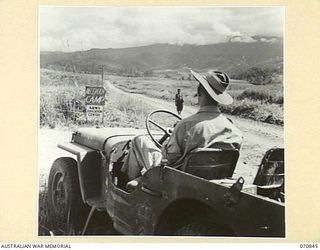 WAU - LAE ROAD, NEW GUINEA, 1944-02-20. THE START OF THE WAU - LAE ROAD PICTURED APPROXIMATELY A MILE FROM THE DETAILS ISSUING DEPOT WHICH LIES NEAR THE CENTRE OF WAU. THE TURNOFF LEADS TO THE WAU ..