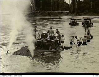 Bougainville, Solomon Islands. 1945-02. Australian Matilda Tanks being dragged across the Puriata River by bulldozers