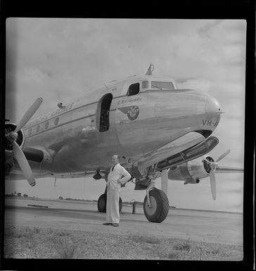 D Davis standing alongside a British Commonwealth Pacific Airlines Skymaster aircraft, VH-BPA, Nadi, Fiji