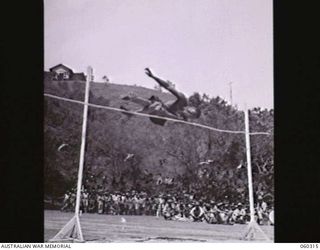 ELA BEACH, NEW GUINEA. 1943-11-13. CORPORAL E E HOFFMAN OF THE 394TH UNITED STATES PORT BATTALION COMPETING IN THE HIGH JUMP AT THE COMBINED SERVICES SPORTS