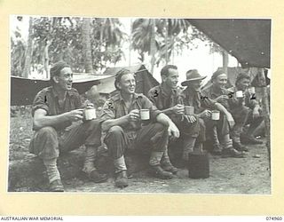 HANSA BAY, NEW GUINEA. 1944-07-29. THE SERVICE POLICE OF THE 30TH INFANTRY BATTALION RELAX DURING THEIR MORNING CUP OF TEA AT THEIR CAMP IN THE POTSDAM PLANTATION. IDENTIFIED PERSONNEL ARE:- ..