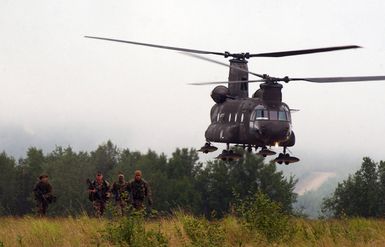 US Marine Corps (USMC) personnel from the Marine Security Element (MSE), India Company, 3rd Battalion, 3rd Marines home based at Kaneohe Bay, Hawaii (HI), run from a US Army (USA) CH-47D Chinook helicopter helicopter from Bravo Company 4-123 Aviation Regiment, stationed at Fort Wainwright Army Post, Alaska (AK), as they prepare for Tactical Recovery of Aircraft and personnel (TRAP) training during Exercise Northern Edge 04, at Eielson Air Force Base (AFB), Alaska (AK)