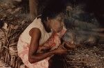 Nevinbong starts a cooking fire using coconut shell and dry grasses