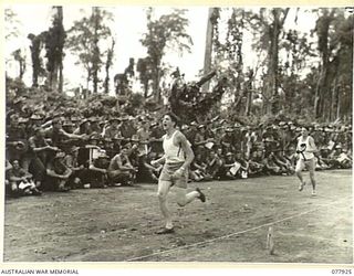 TOROKINA, BOUGAINVILLE ISLAND. 1945-01-01. SIGNALLER K.A. GRAY, 3RD DIVISION SIGNALS WINNING THE FINAL OF THE 880 YARDS CHAMPIONSHIP AT THE ATHLETIC MEETING ON THE SPORTS ARENA MEMORIAL PARK ..