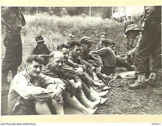 SX15733 CAPTAIN M.G. GRATTON, REGIMENTAL MEDICAL OFFICER OF THE 57/60TH INFANTRY BATTALION, 15TH INFANTRY BRIGADE, INSPECTING THE FEET OF NO. 10 PLATOON, "B" COMPANY. IDENTIFIED PERSONNEL ARE: ..