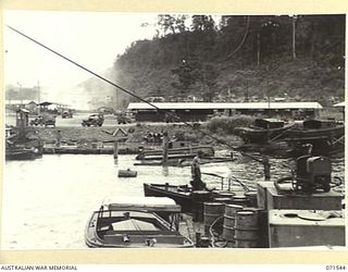 LAE, NEW GUINEA. 1944-03-23. AUSTRALIAN IMPERIAL FORCE AND UNITED STATES TRANSPORTATION SECTION AT HEADQUARTERS, LAE BASE SUB-AREA VIEWING SMALL CRAFT ON THE SLIPS AND THE AMERICAN PORT COMPANY IN ..