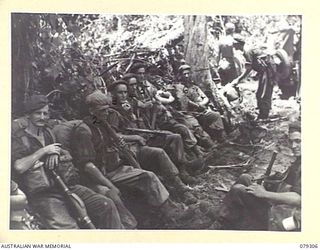 BOUGAINVILLE ISLAND. 1945-02-27. PERSONNEL OF THE 9TH INFANTRY BATTALION, CARRYING FULL PACKS, RESTING AFTER PLOUGHING THROUGH HEAVY MUD ON THE MAWARAKA- MOSIGETTA ROAD. IDENTIFIED PERSONNEL ARE:- ..