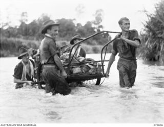 MALAS RIVER, NEW GUINEA. 1944-05-27. FORWARD TROOPS OF THE 35TH INFANTRY BATTALION CROSS THE RIVER WITH THEIR EQUIPMENT LOADED ON AN ABANDONED JAPANESE HAND CART, DURING THEIR ADVANCE TOWARDS ..