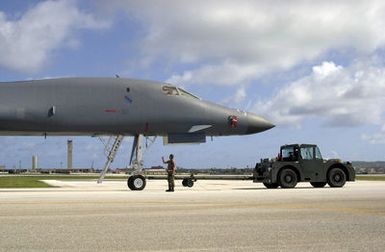 US Air Force (USAF) maintenance members use a MB-2 aircraft tow tractor to position a USAF B-1B Lancer into position on the ramp at Andersen Air Force Base (AFB), Guam. The B-1B and maintainers are here in support of the 7th Air Expeditionary Wing's (AEW) mission