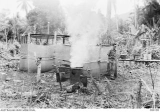 GOODENOUGH ISLAND, NEW GUINEA. 1942-10. IMITATION KITCHENS WITH FIRES CONTINUOUSLY BURNING WERE PART OF THE BLUFF AND DECEPTION PRACTICED BY A SMALL FORCE OF AUSTRALIANS WHO SEIZED THE ISLAND AND ..