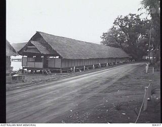 MILNE BAY, PAPUA. THE AUSTRALIAN COMFORTS FUND HUT AT HMAS LADAVA, A LONG TRADITIONAL NATIVE THATCHED ATTAP BUILDING. (NAVAL HISTORICAL COLLECTION)