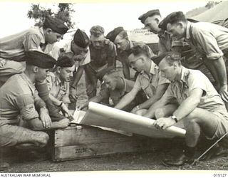 1943-06-26. NEW GUINEA. AUSTRALIAN BEAUFIGHTER CREWS, RECEIVING LAST MINUTE INSTRUCTIONS FROM F/O S.R. HUTCHINSON AT A NEW GUINEA BASE. LEFT TO RIGHT (KNEELING) SGT. D.C. KIRKWOOD OF SMITHFIELD, ..