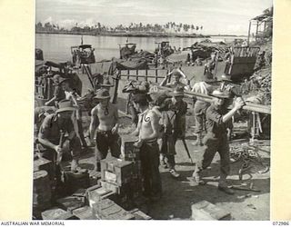 MADANG, NEW GUINEA. 1944-04-24. TROOPS OF THE 5TH DIVISION UNLOADING AMMUNITION AND EQUIPMENT SOON AFTER THEIR ARRIVAL FROM SAIDOR