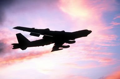 A right underside view of a B-52 Stratofortress aircraft taking off at sunset during exercise Distant Mariner