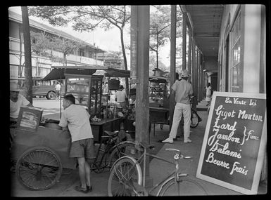 Street scene, food carts along shops, store sign in french, Papeete, Tahiti