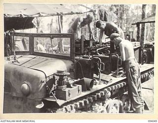 BOUGAINVILLE, 1945-07-16. MECHANICS OF 312 LIGHT AID DETACHMENT, ATTACHED 29 INFANTRY BRIGADE, OVERHAULING A JAPANESE PRIME MOVER. USED TO HAUL ENEMY GUNS THREE WEEKS AGO IT WILL NOW BE USED TO ..