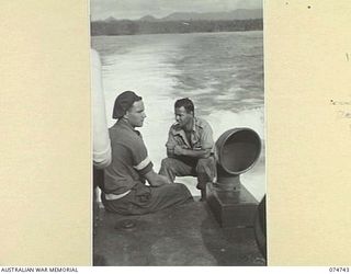 MILILAT, NEW GUINEA. 1944. PERSONNEL OF HEADQUARTERS, 5TH DIVISION ENJOY A QUIET SMOKE IN THE STERN OF THE COURIER BARGE OF THE 593RD UNITED STATES BARGE COMPANY DURING THE RUN BETWEEN MADANG AND ..