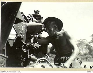 BOUGAINVILLE ISLAND, 1944-11-17. VX83139 CRAFTSMAN J.A. KERMOND, 4TH FIELD REGIMENT, SIGHT TESTING ON A 25 POUNDER GUN WHILE MAKING A GERNERAL OVERHAUL OF EQUIPMENT BEFORE TAKING OVER FROM THE ..