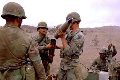 Members of B Battery, 7th Bn., 8th Field Artillery Regiment, 25th Inf. Div., prepare a 105mm shell for firing from an M-102 howitzer during a live-fire exercise at the Pohakuloa Training Area