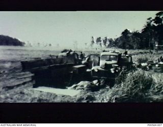 Trucks unloading material for the camp site of No 2 Airfield Contruction Squadron in the Markham Valley