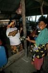 Women play ukulele, guitar at party