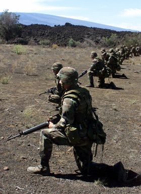 US Marines from 1ST Battalion, 3rd Marines, Weapons Company, armed with M16 rifles rest in a kneeling position during a training exercise at Pohakuloa Training Area on the Big Island of Hawaii