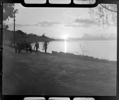 Papeete waterfront, Tahiti during sunset, showing horse drawn cart and men who have finished fishing