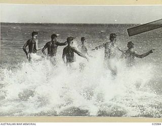 PORT MORESBY, PAPUA. 1942-07-20. AUSTRALIAN TROOPS RUSHING INTO THE SHALLOWS FOR A REFRESHING PLUNGE AFTER A DAY'S WORK